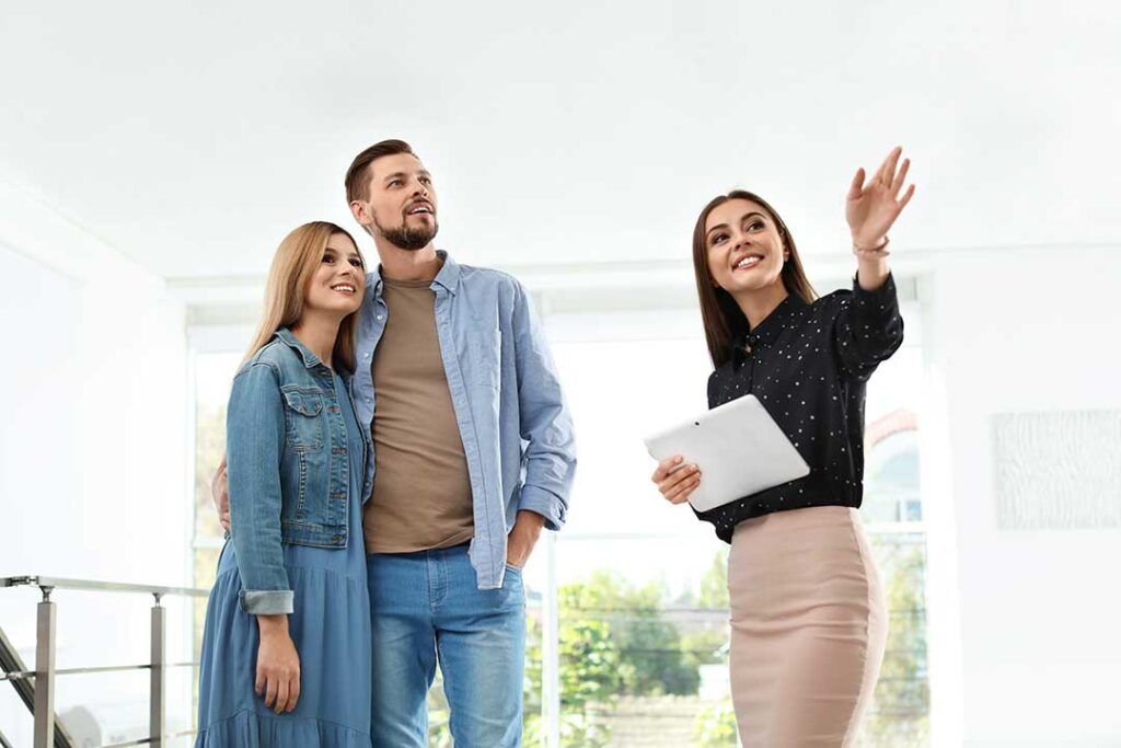 Homeowners reviewing renovation plans beside a bright kitchen with updated cabinets, flooring, and energy-efficient lighting.