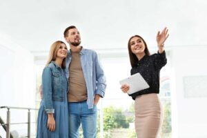 Homeowners reviewing renovation plans beside a bright kitchen with updated cabinets, flooring, and energy-efficient lighting.